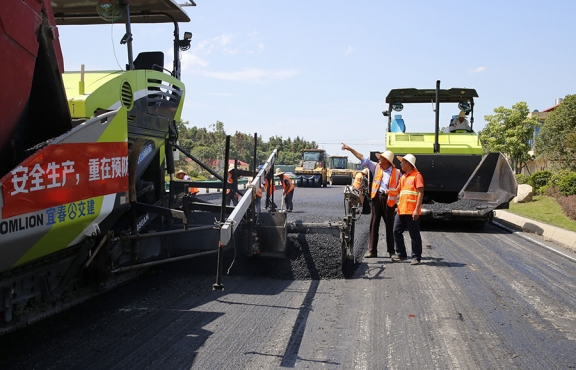 攤鋪機(jī)、壓路機(jī)等設(shè)備緊張有序運(yùn)行，高達(dá)170℃的瀝青混合料炙烤著公路人